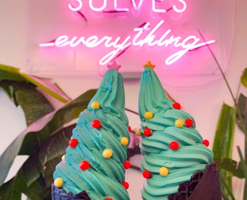 iHalo Krunch christmas themed ice cream with charcoal cones in front of Ice Cream Solves everything neon sign