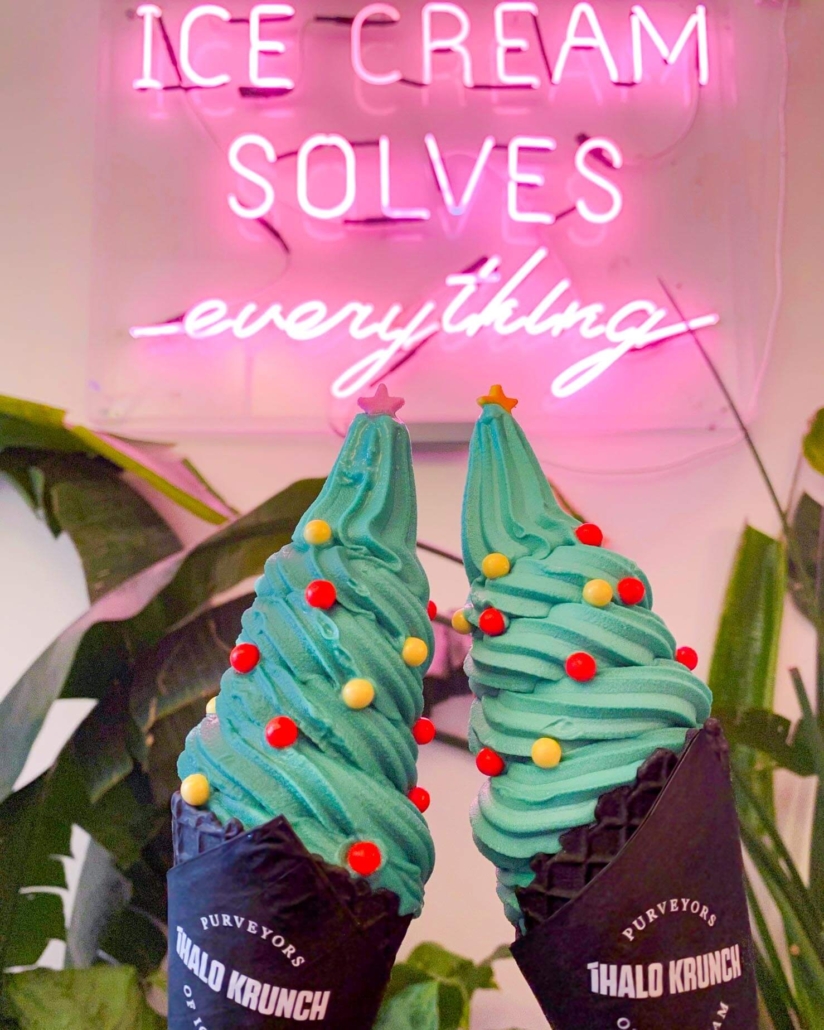 iHalo Krunch christmas themed ice cream with charcoal cones in front of Ice Cream Solves everything neon sign