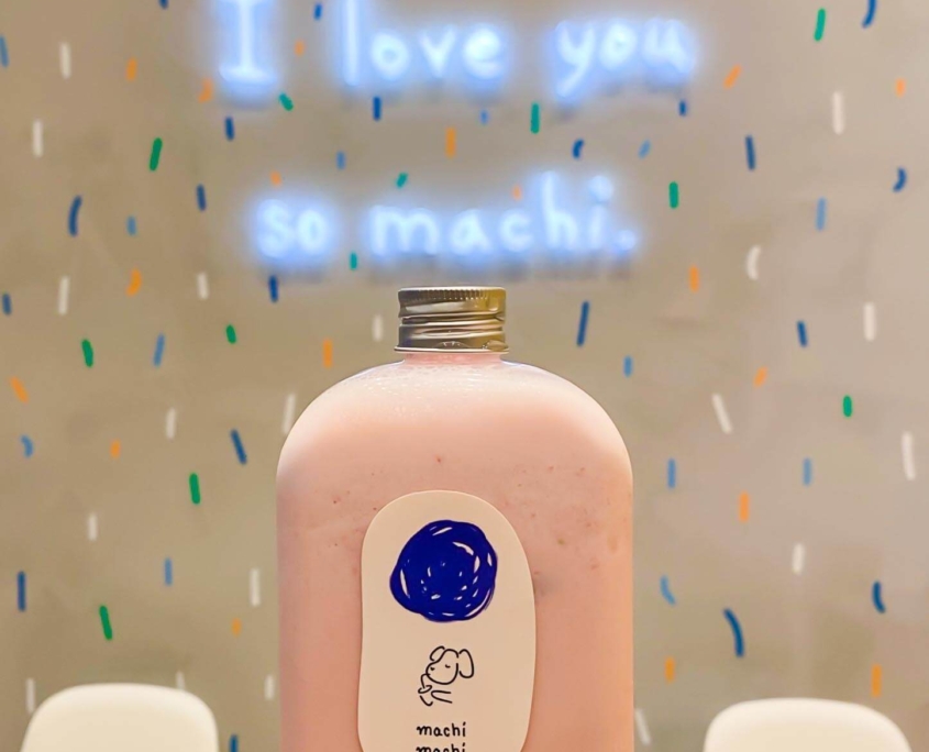 Machi Machi strawberry panna cotta bubble tea in front of I love you so machi sign