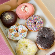 Six vegan sprinkle donuts in a box
